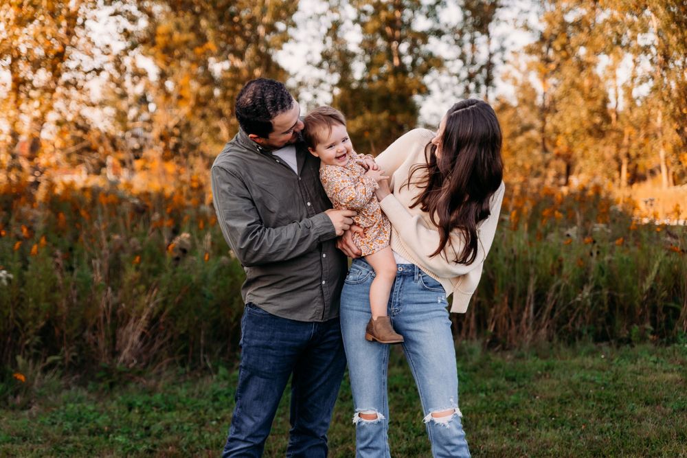 Family sharing candid moments together during autumn outdoor photo session.