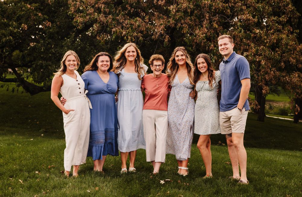 Group photo of people wearing coordinated blue and white outfits in an outdoor setting.