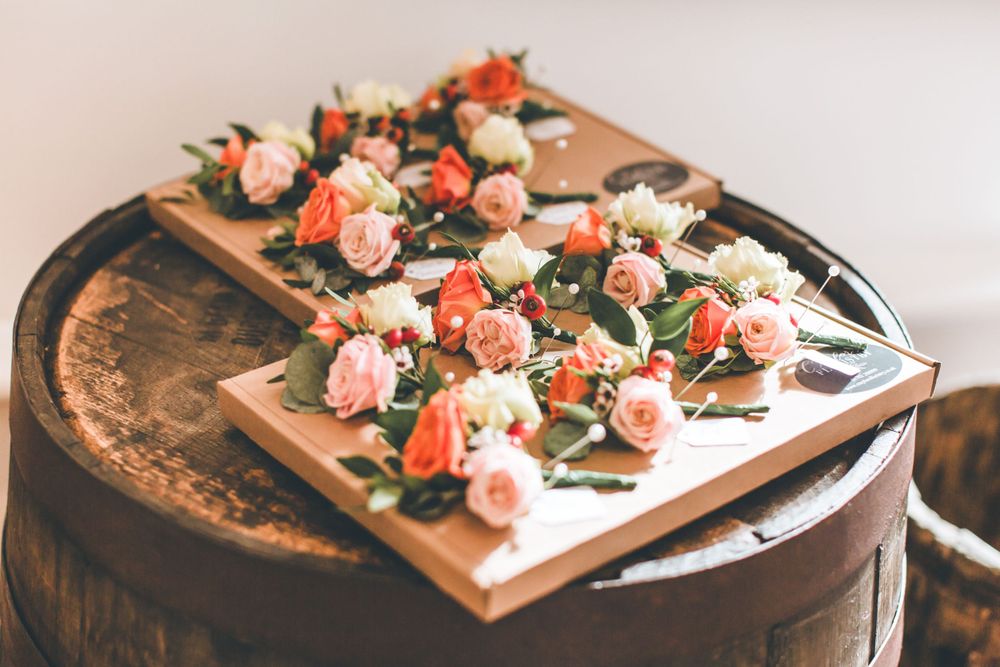 Pink and white floral arrangements displayed on rustic wooden boards create an elegant wedding tablescape.
