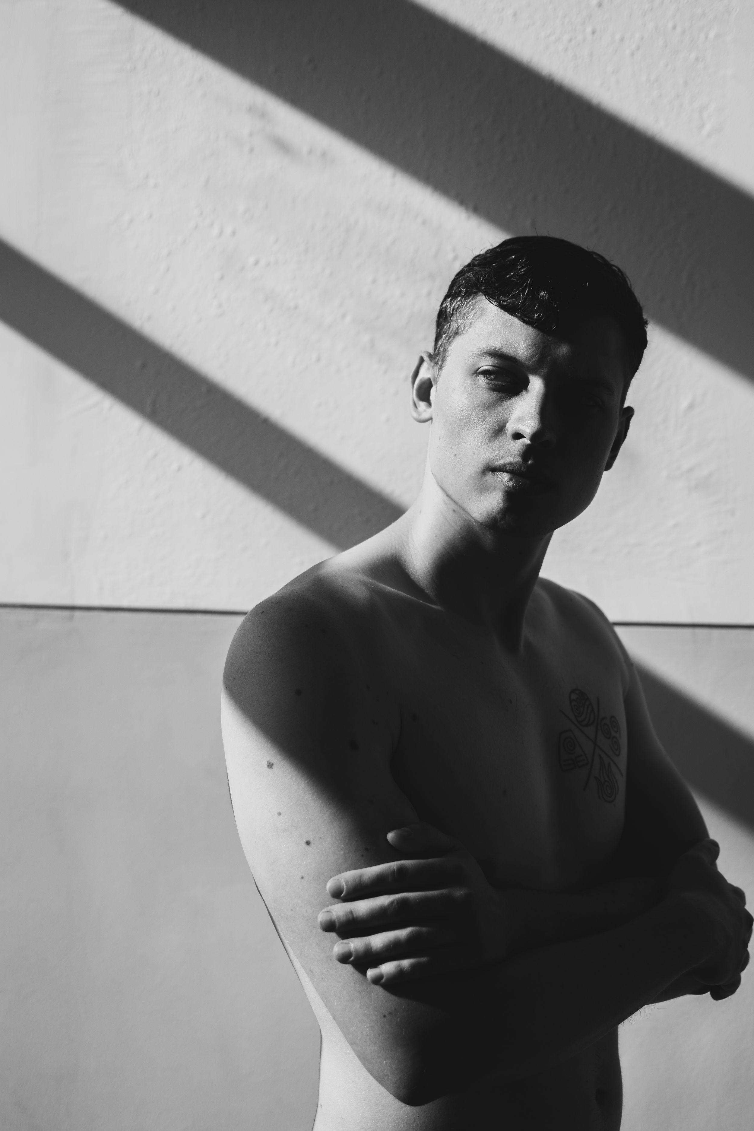 Dramatic black and white portrait with strong diagonal shadows.