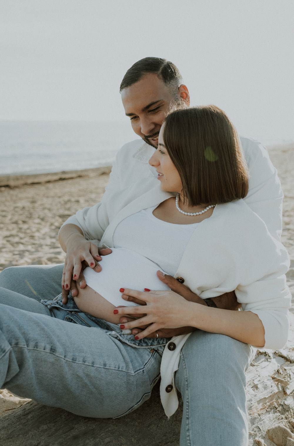 Babybump à la plage au lever de soleil avant l'arrivée de leur petite