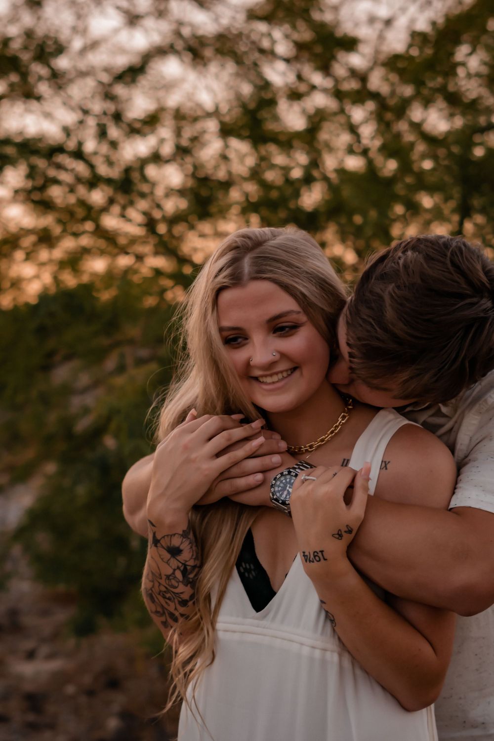 engaged couple with male kissing females neck