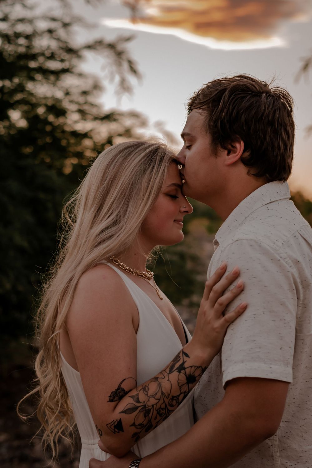 sunset engagement photo kissing forehead