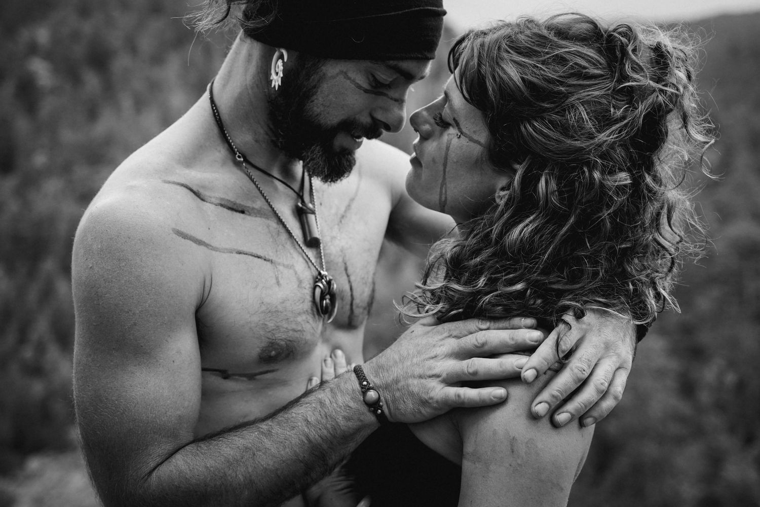 Intimate black and white portrait of couple embracing outdoors.