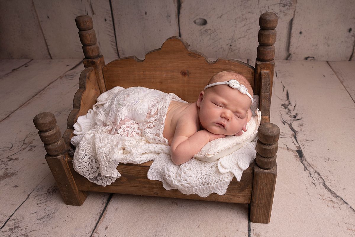 simple posed on baby's hand styled with textured blanket in a sleepy pose