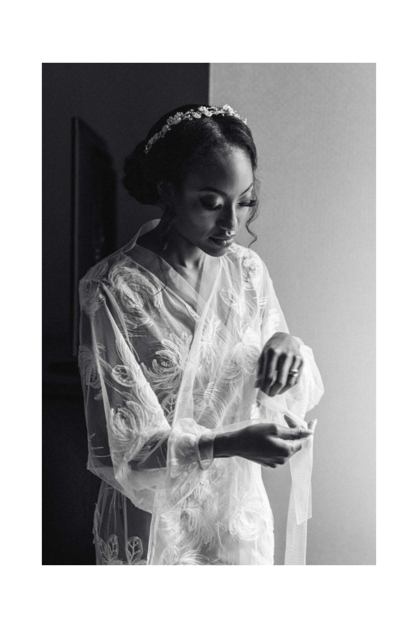 A bride in a delicate white lace robe prepares for her wedding day.