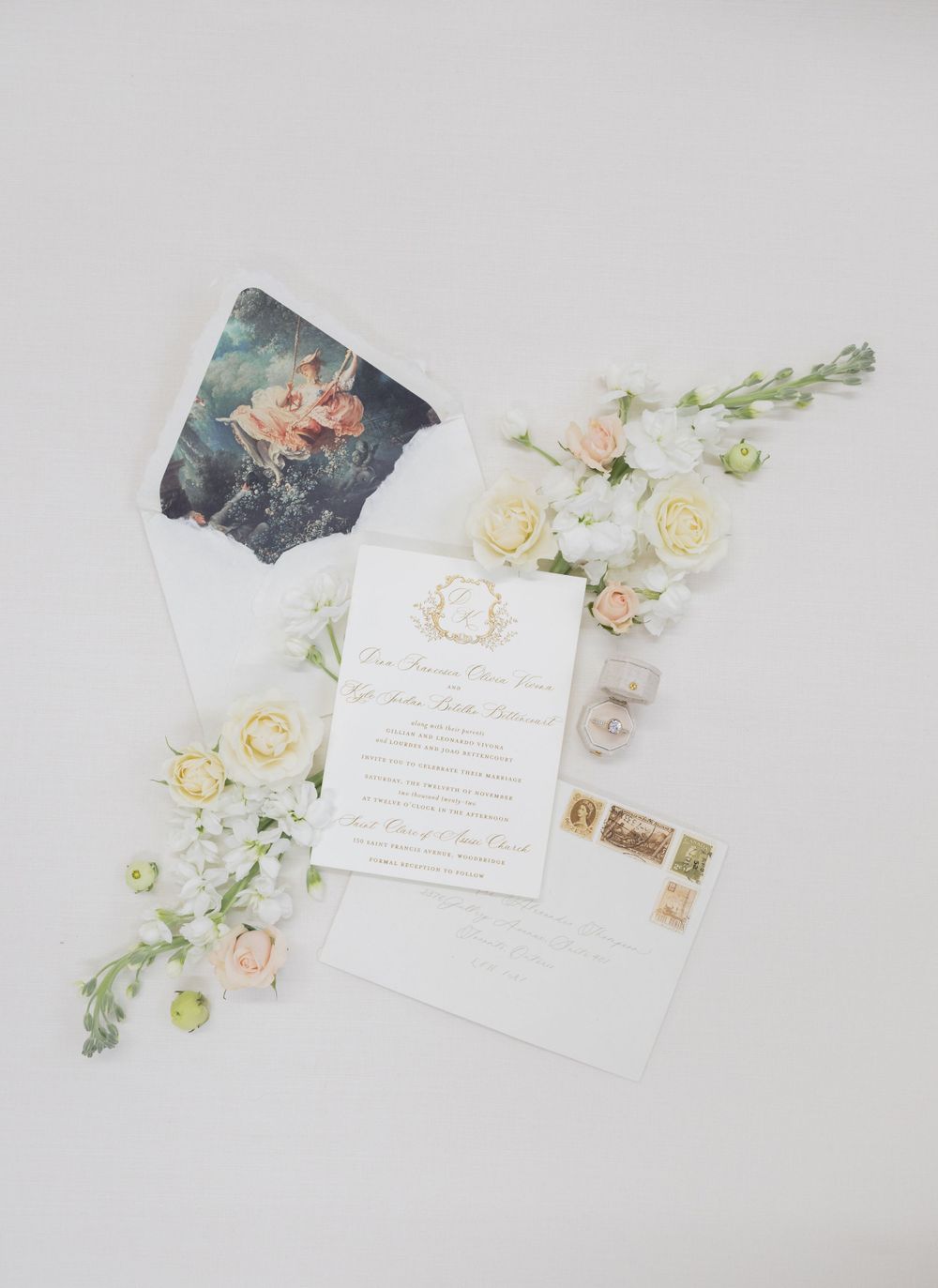 Elegant wedding invitation with dark floral envelope liner and cream roses on white background.