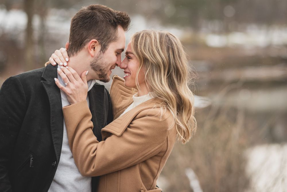A couple sharing an intimate moment outdoors during a winter engagement session.