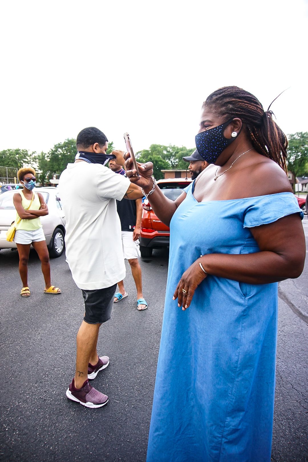 People gathering in a parking lot during what appears to be a celebration event.