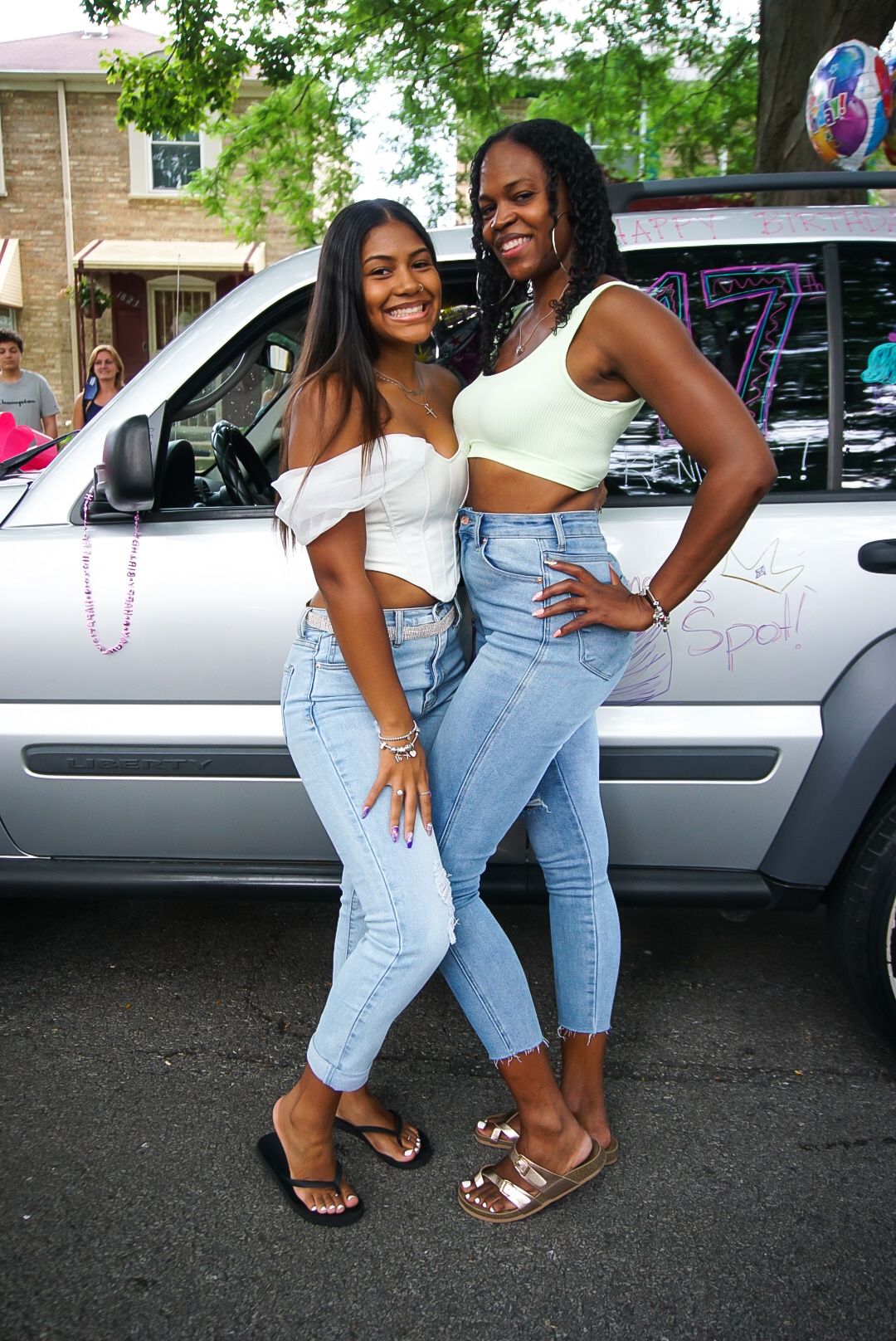 A celebratory summer scene with matching outfits in front of a decorated silver SUV.