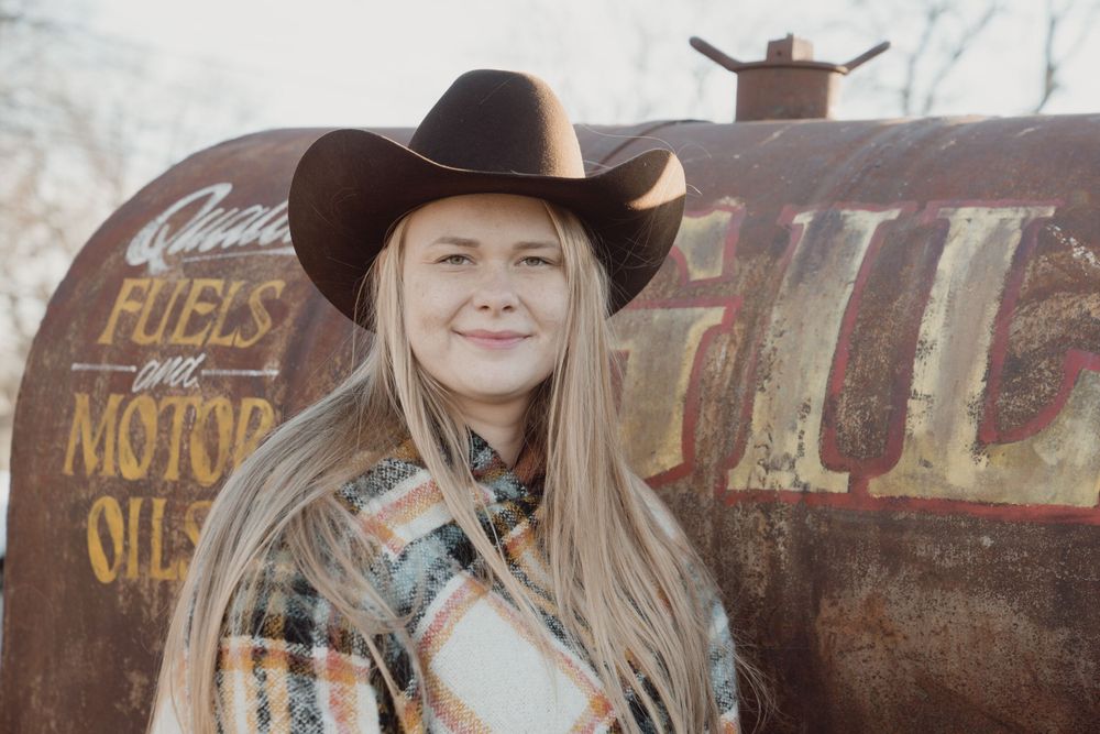 Blond women in a cowboy hat posing for a portrait