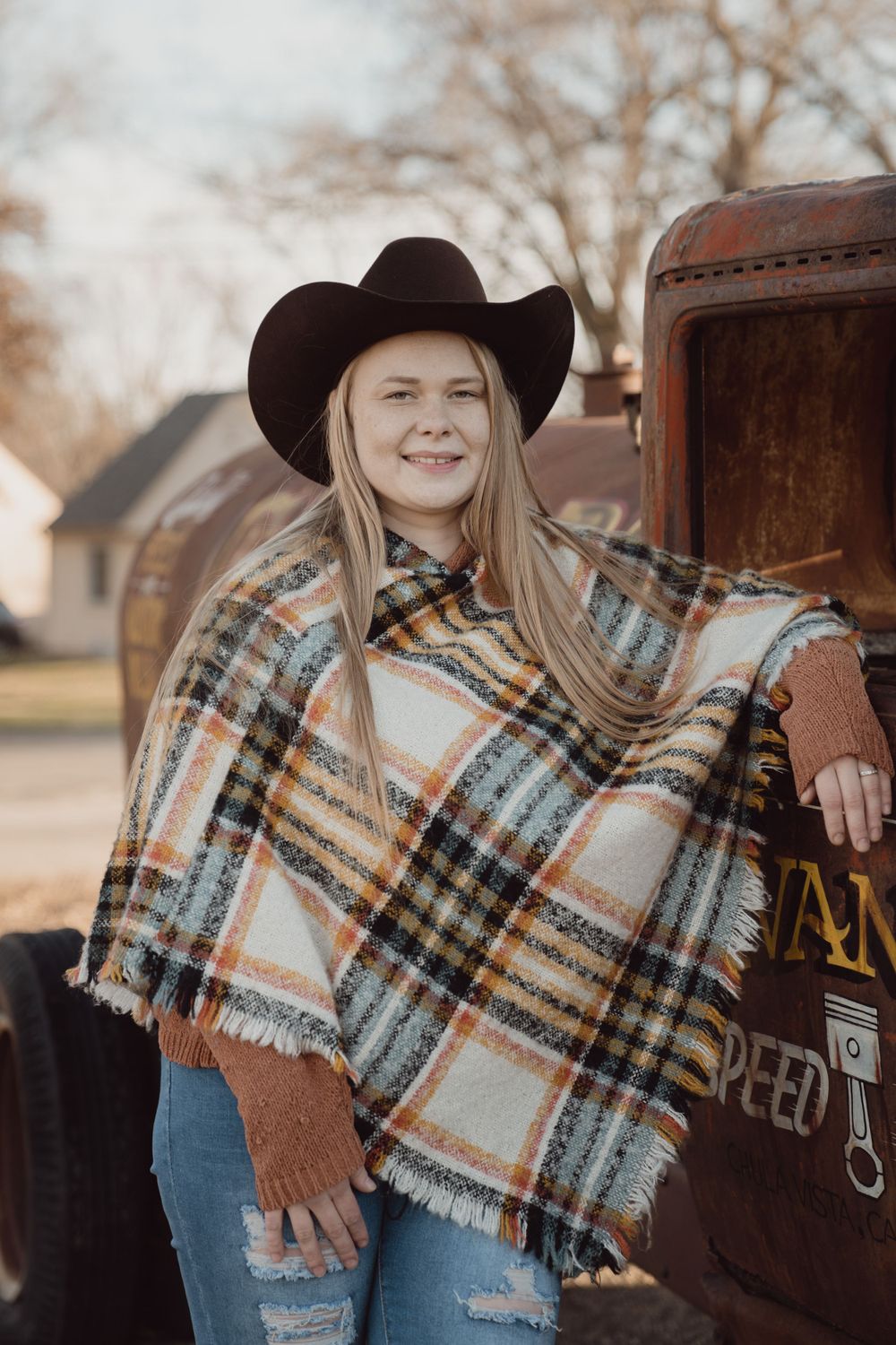 Blond women in cowboy hat standing in front of a vintage truck