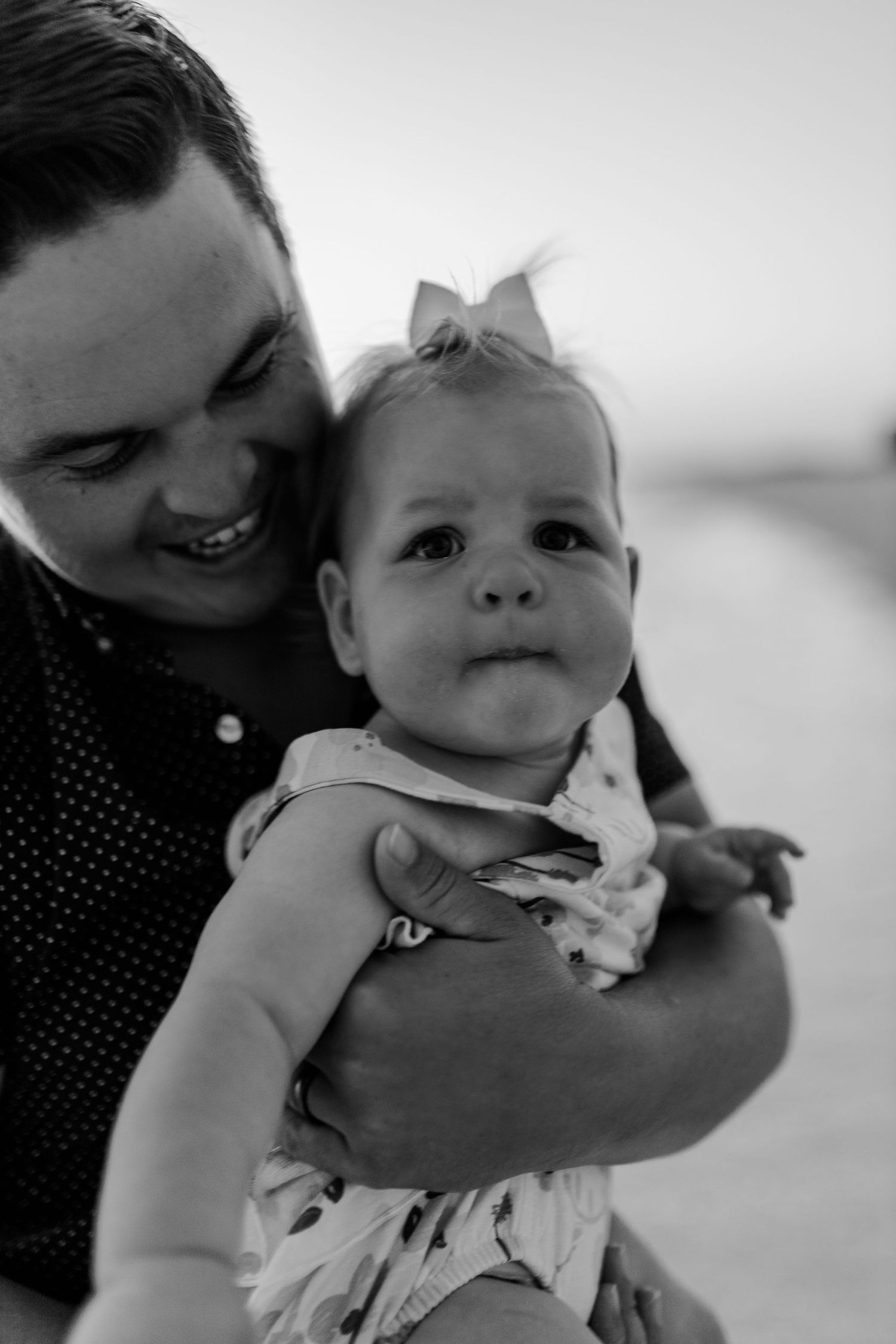 Black and white portrait capturing a joyful moment between parent and baby.