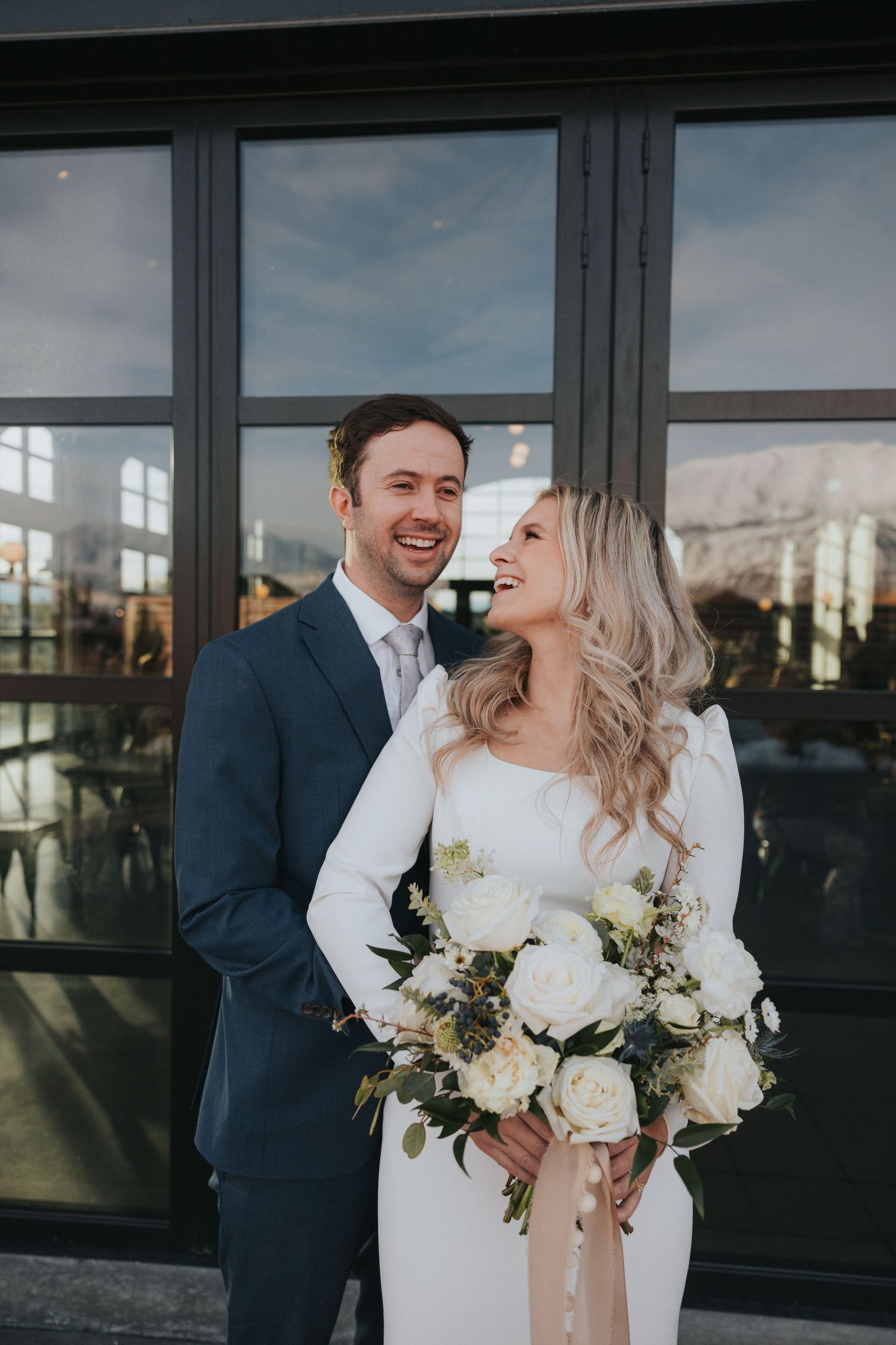 bride and groom laugh with one another during their utah winter wedding with their affordable local photographer
