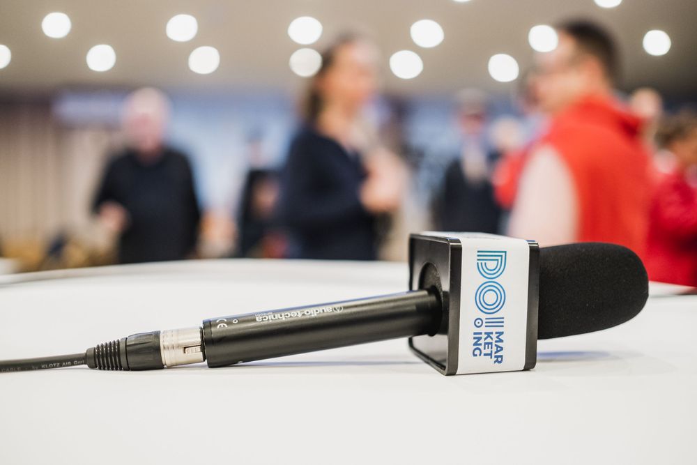 Close-up of professional microphone on white table at conference event.