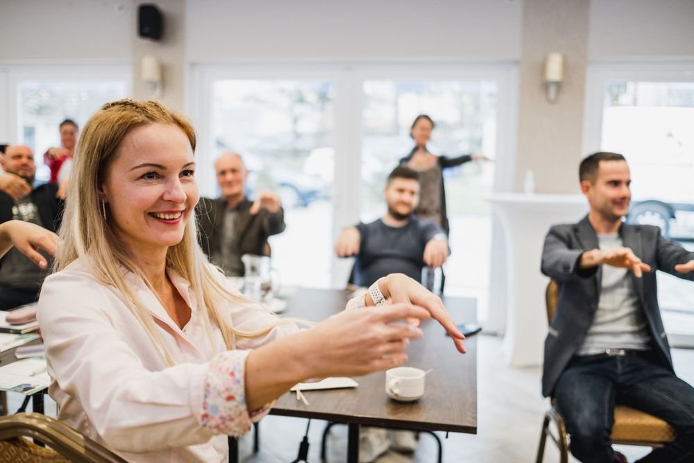 Engaged participants smiling and interacting during an interactive workshop session.