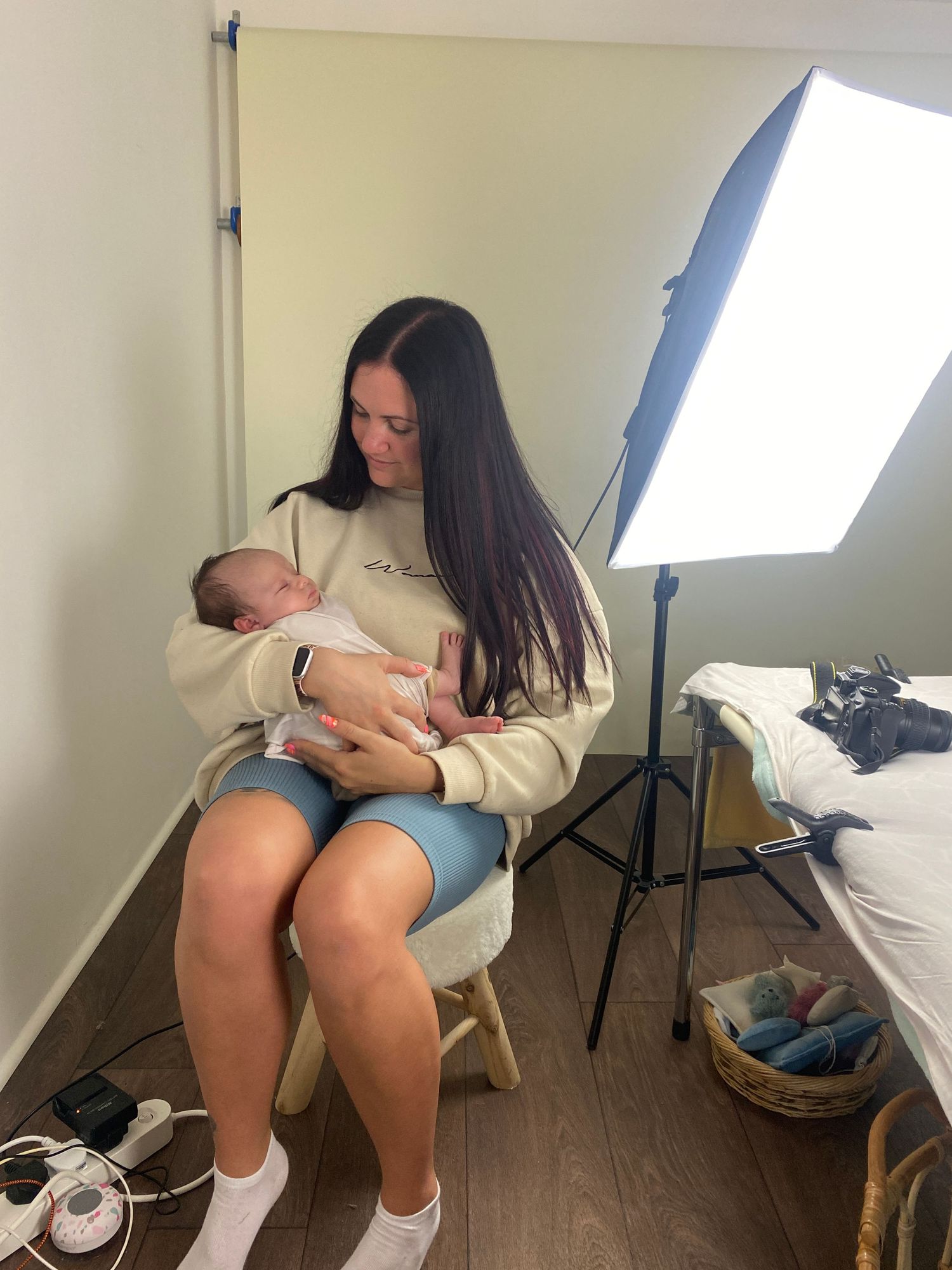 Photographer holding newborn baby in photography studio during newborn photoshoot in Doncaster.