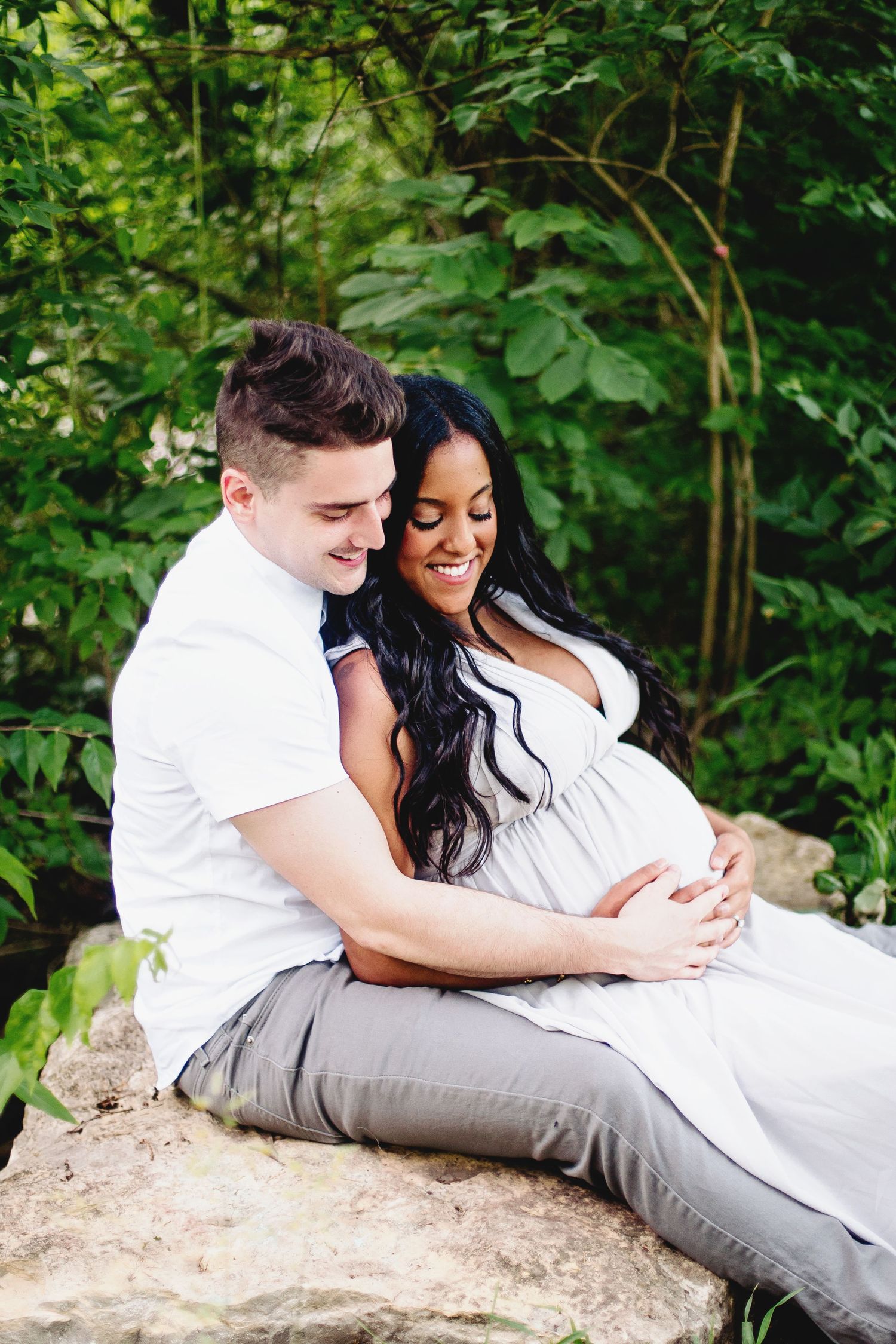 couple sitting and looking at the woman's pregnant belly