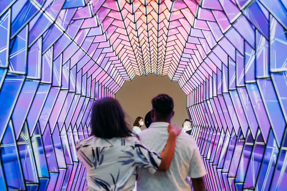 Same sex couple walking through one way color tunnel art exhibit at SFMoMA.