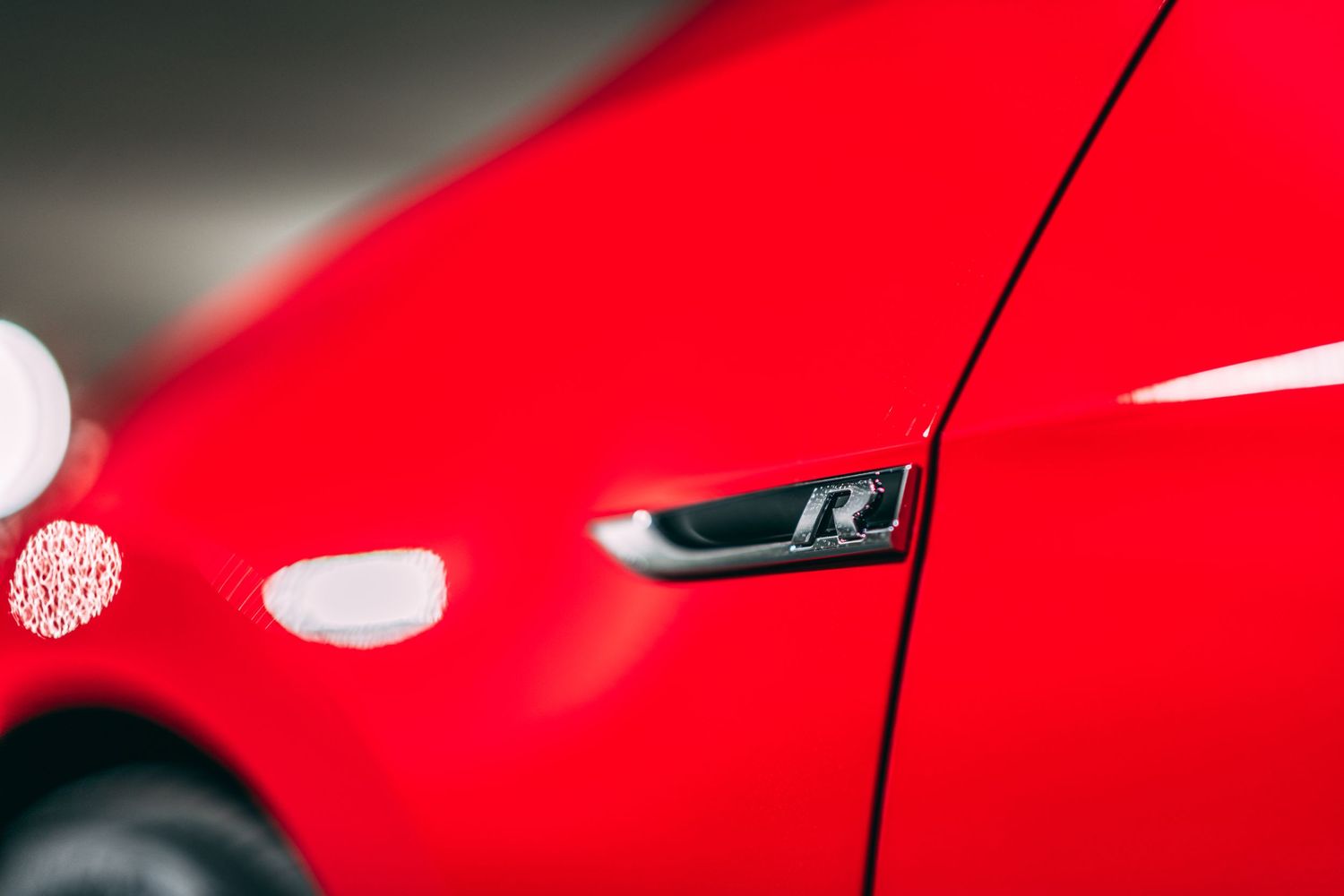 'R' badge detail on red automotive bodywork.