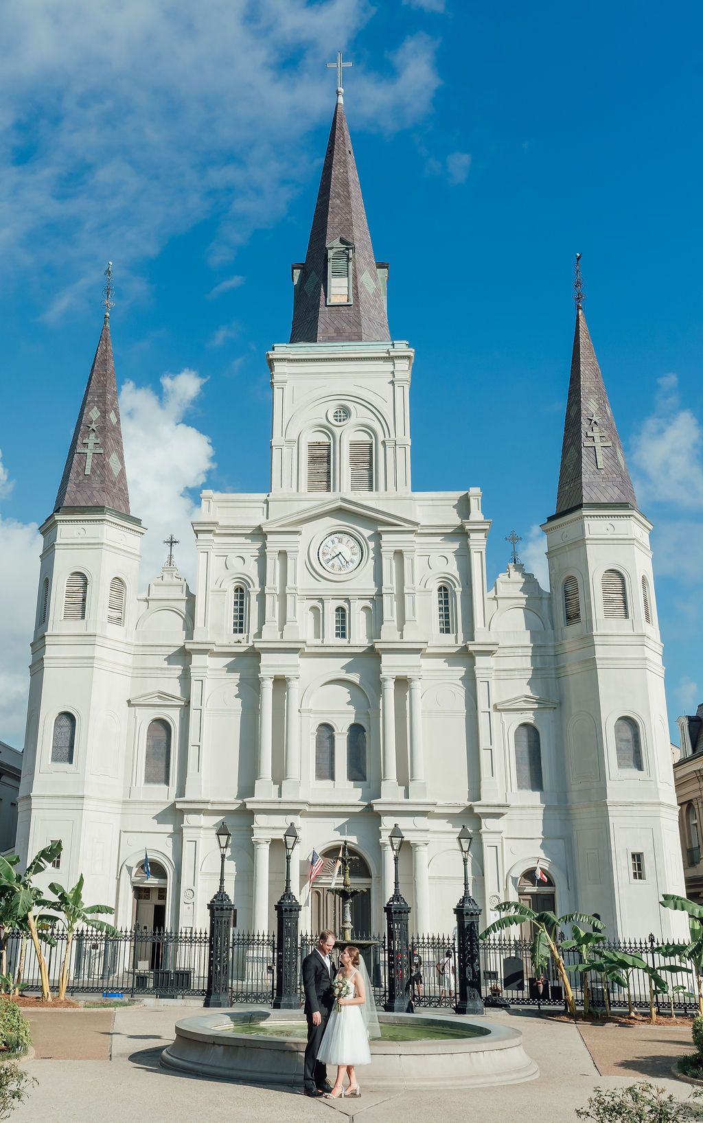 A newly married couple share some sweet words while looking at each other in front of the St. Louis Cathedral.