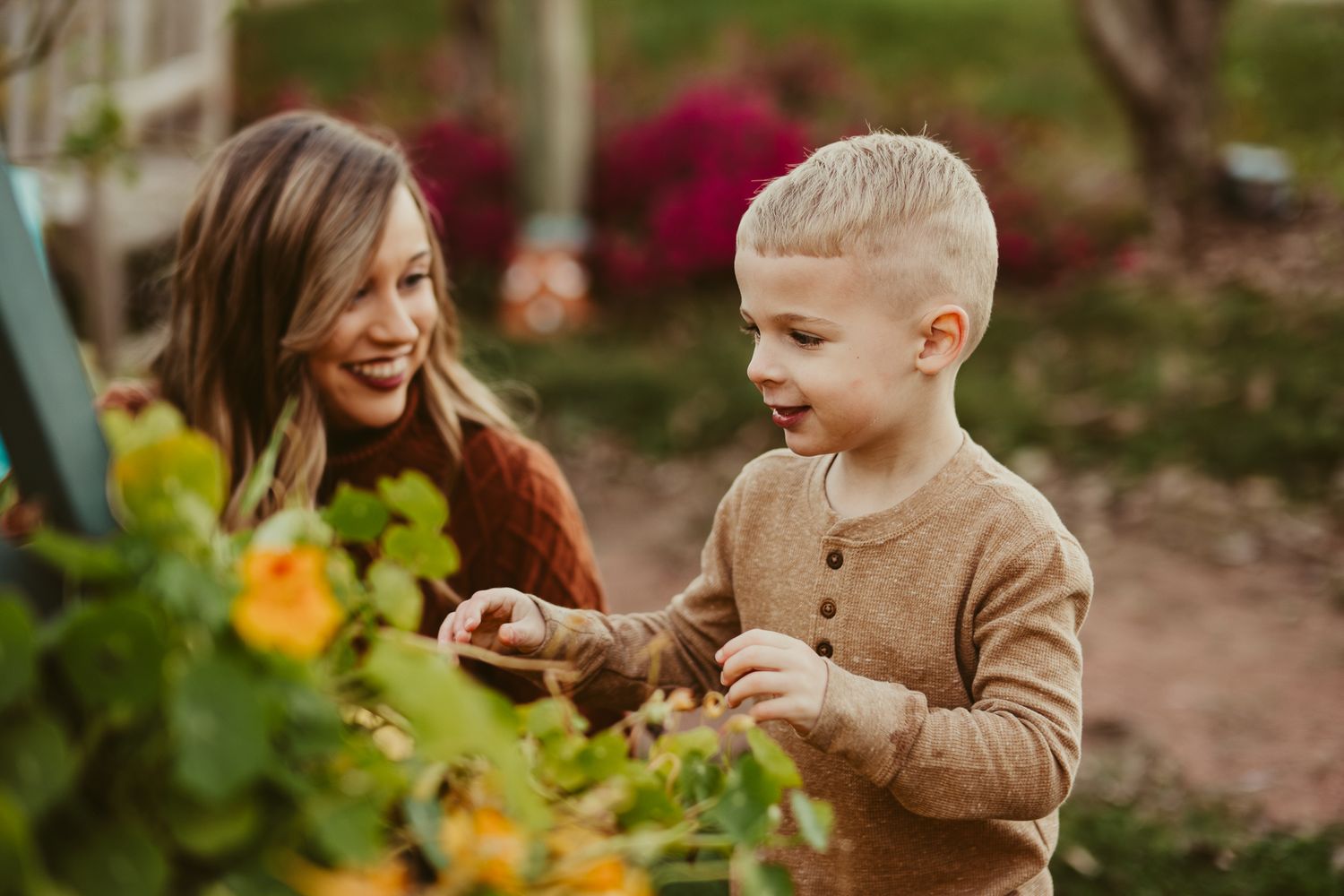 Joyful moment exploring garden flowers together on sunny day.