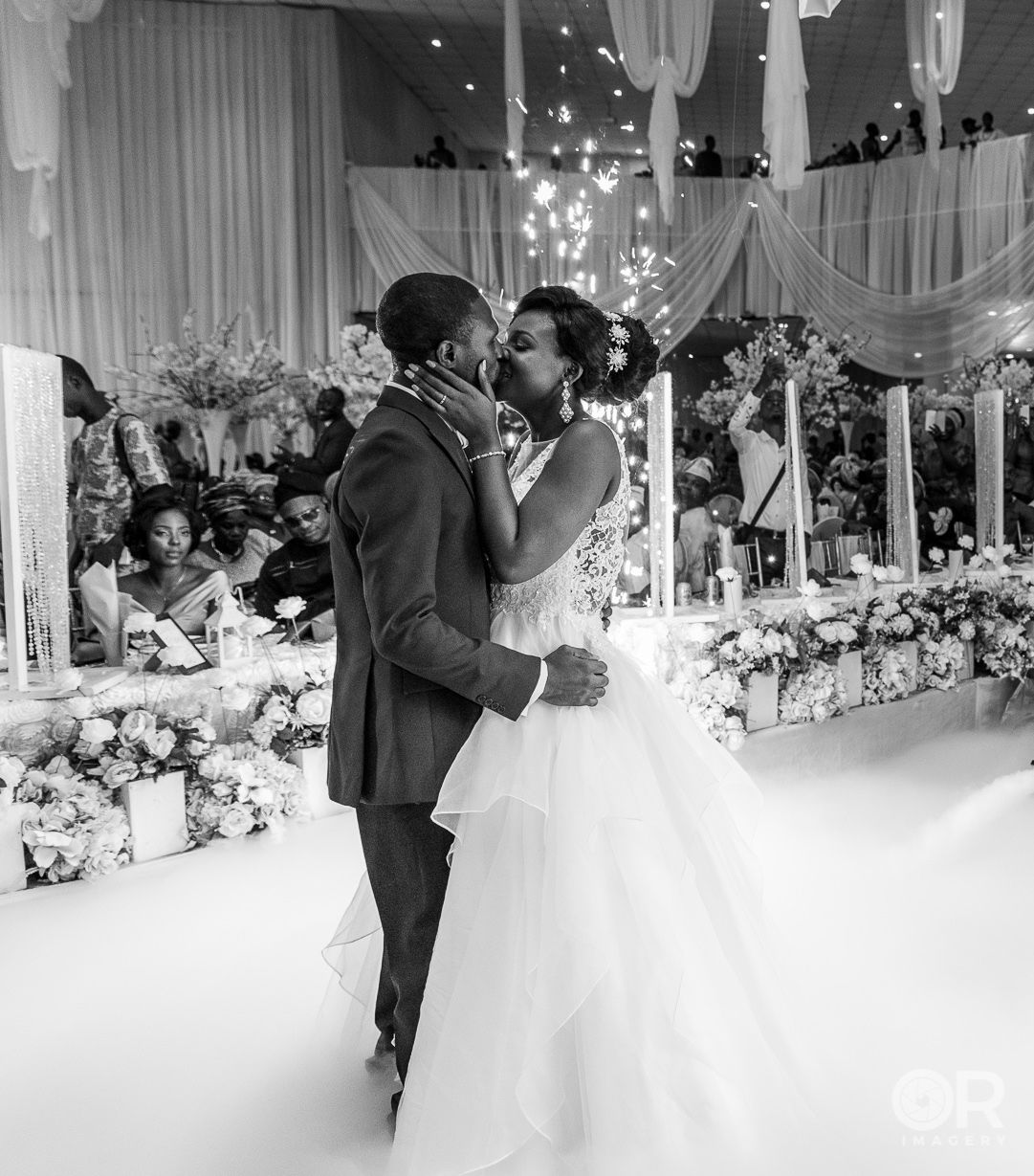 A romantic moment between newlyweds dancing in an elegantly decorated reception venue.