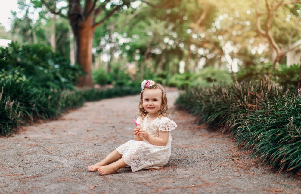 Natural outdoor portrait on dirt path surrounded by tropical plants.