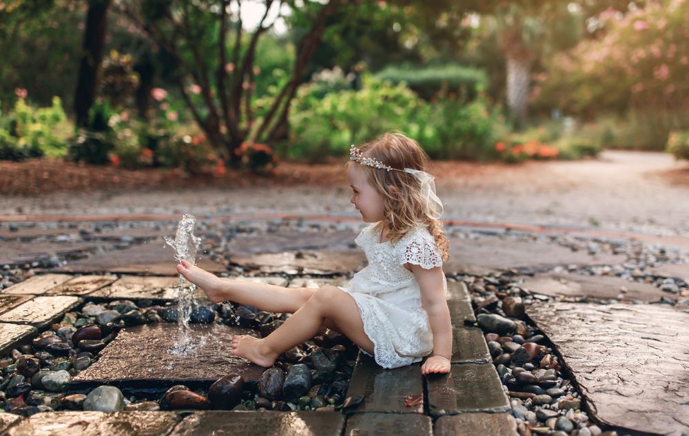 Playing with water on wooden deck in garden setting.