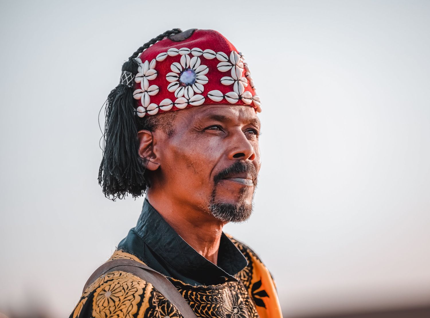 Close-up portrait view of a person wearing traditional warrior costume and red bandana.