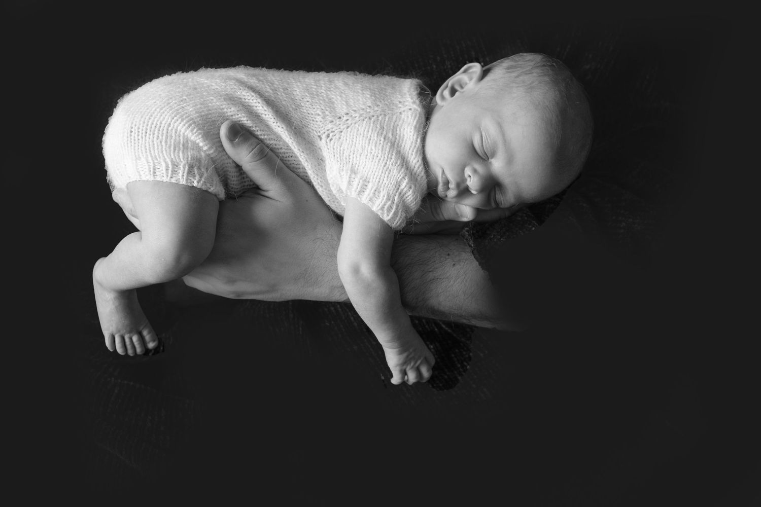 Fine Art image of newborn baby in daddy's arms, taken by Sweet Sol Photo in Queens studio.