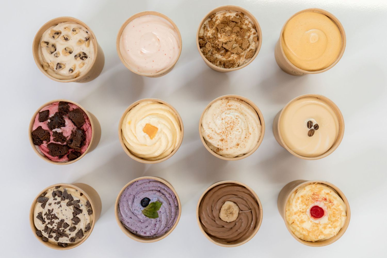 A row of 3 by 4 pints of ice cream all different flavors and colors