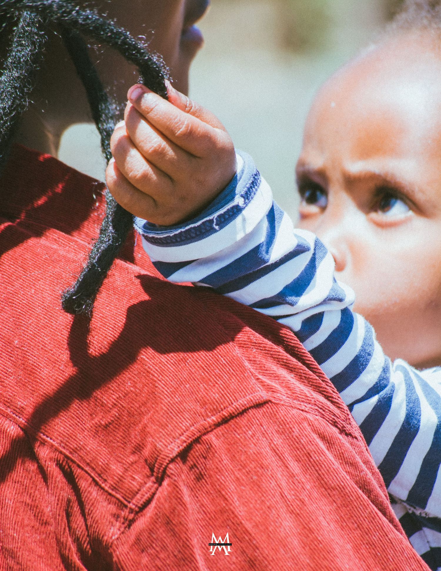 child being held and playing with hair