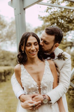 Intimate wedding couple portrait with gentle embraces in natural lighting.