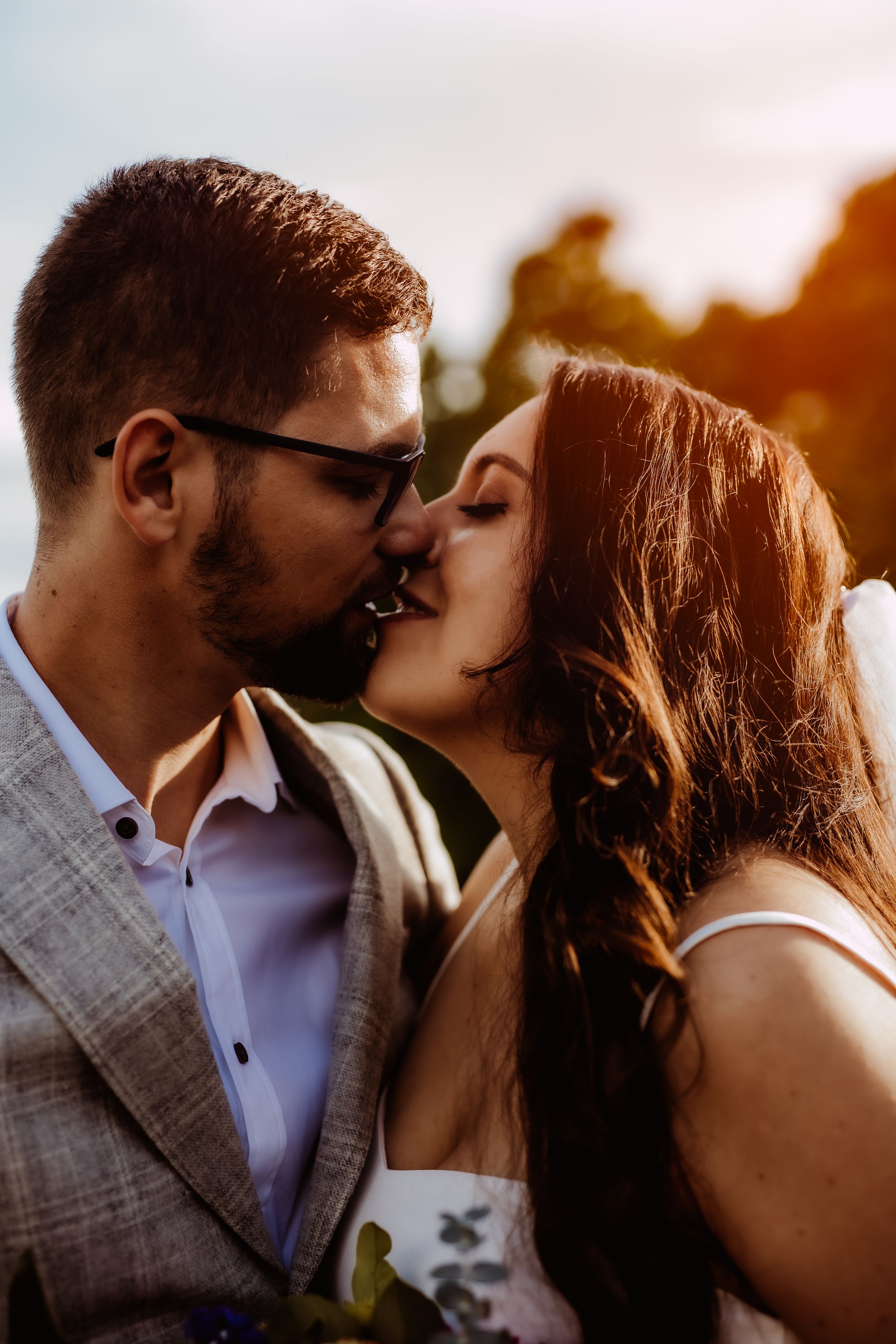 Intimate sunset portrait of newlyweds sharing a tender moment.