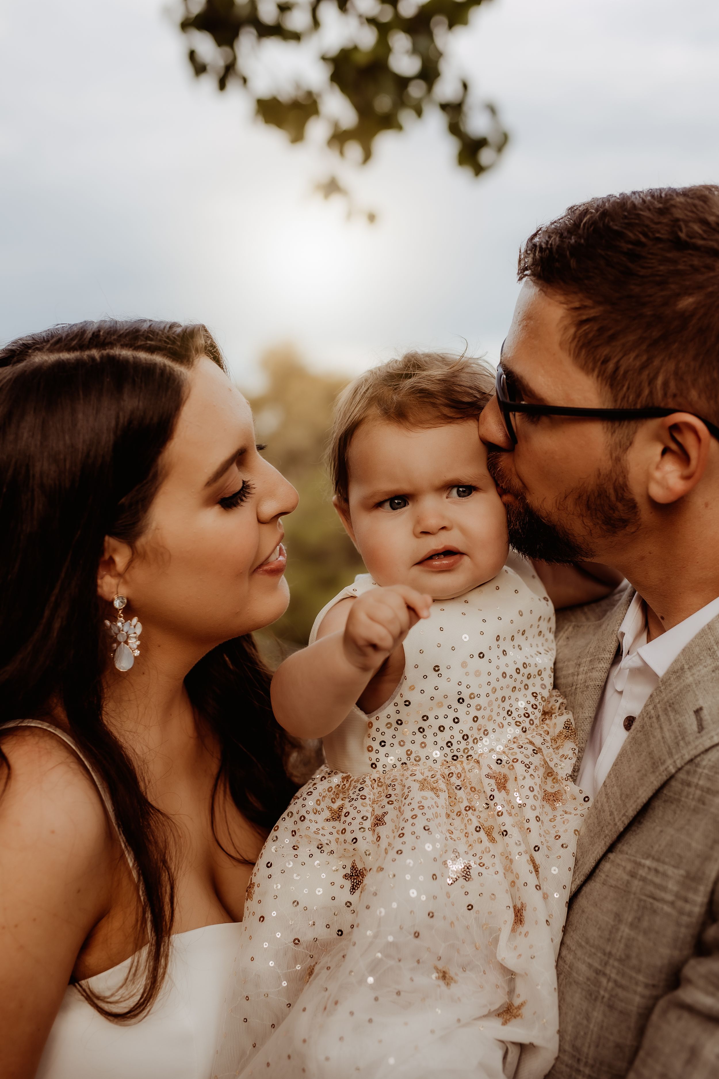 Family sharing tender moment together during outdoor portrait session.