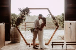 A romantic sunset wedding photoshoot on a wooden dock overlooking the water.