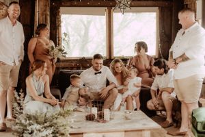 Wedding celebration inside rustic wooden venue with string lights and festive atmosphere.