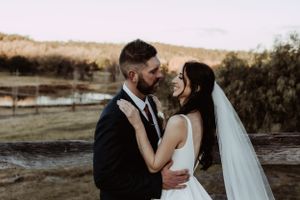 Romantic wedding portraits taken at golden hour in a rustic outdoor setting.