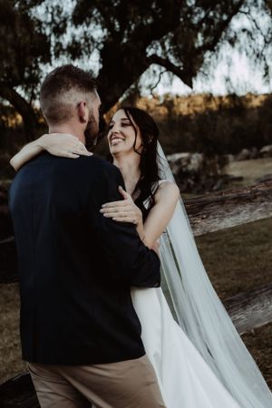Intimate wedding portraits captured in natural outdoor setting during sunset.
