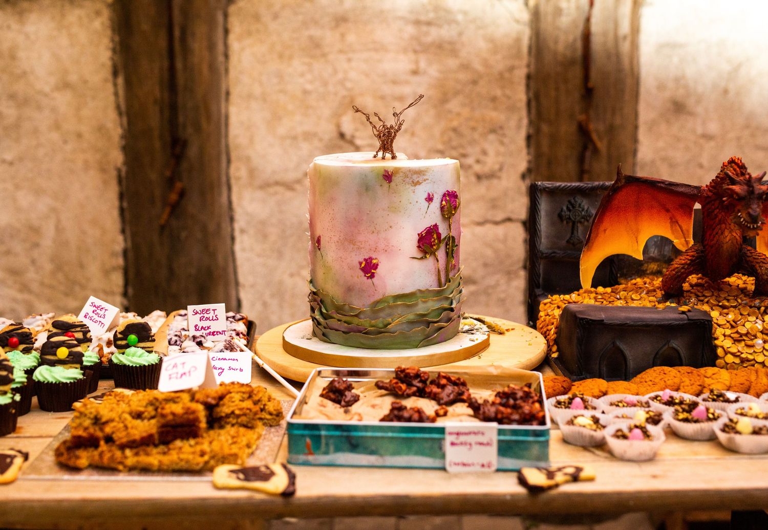 Rustic wooden table display of various desserts and treats at a wedding reception.