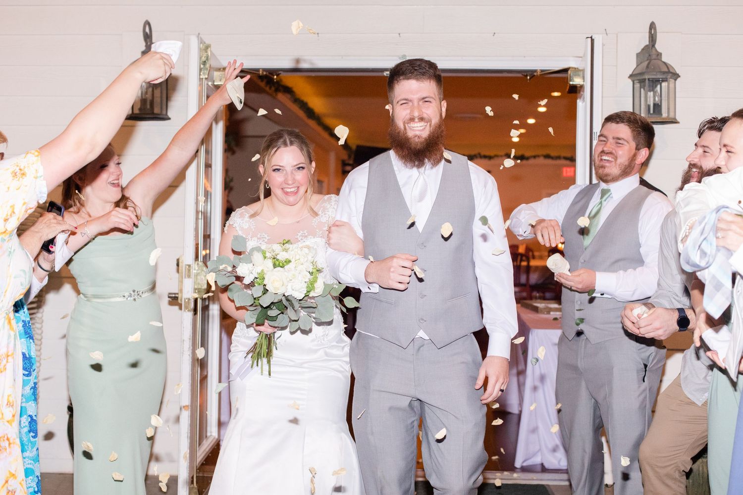 Wedding party members in gray and white attire celebrating during reception festivities.