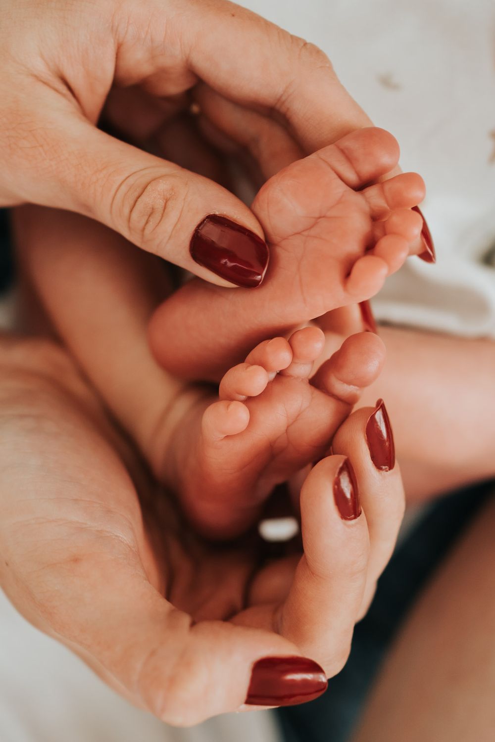 mama obejmuje stópki dziecka - sesja domowa Kraków