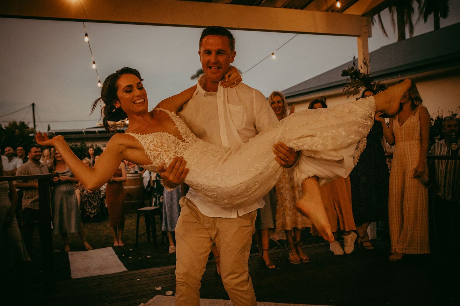 Romantic dance lift captured during a sunset wedding reception.
