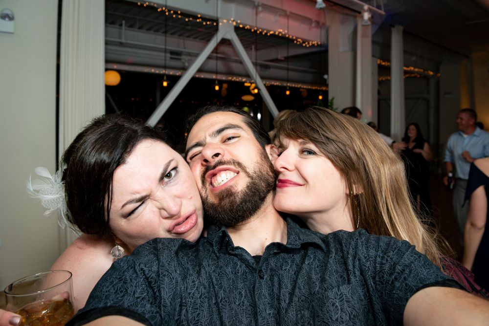 Friends celebrating at dimly lit party with festive atmosphere.