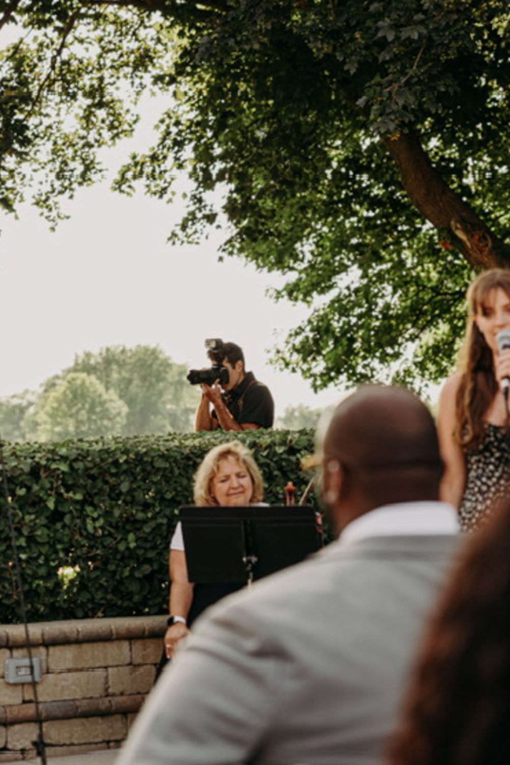 A wedding photographer works from an elevated position to capture ceremony moments.