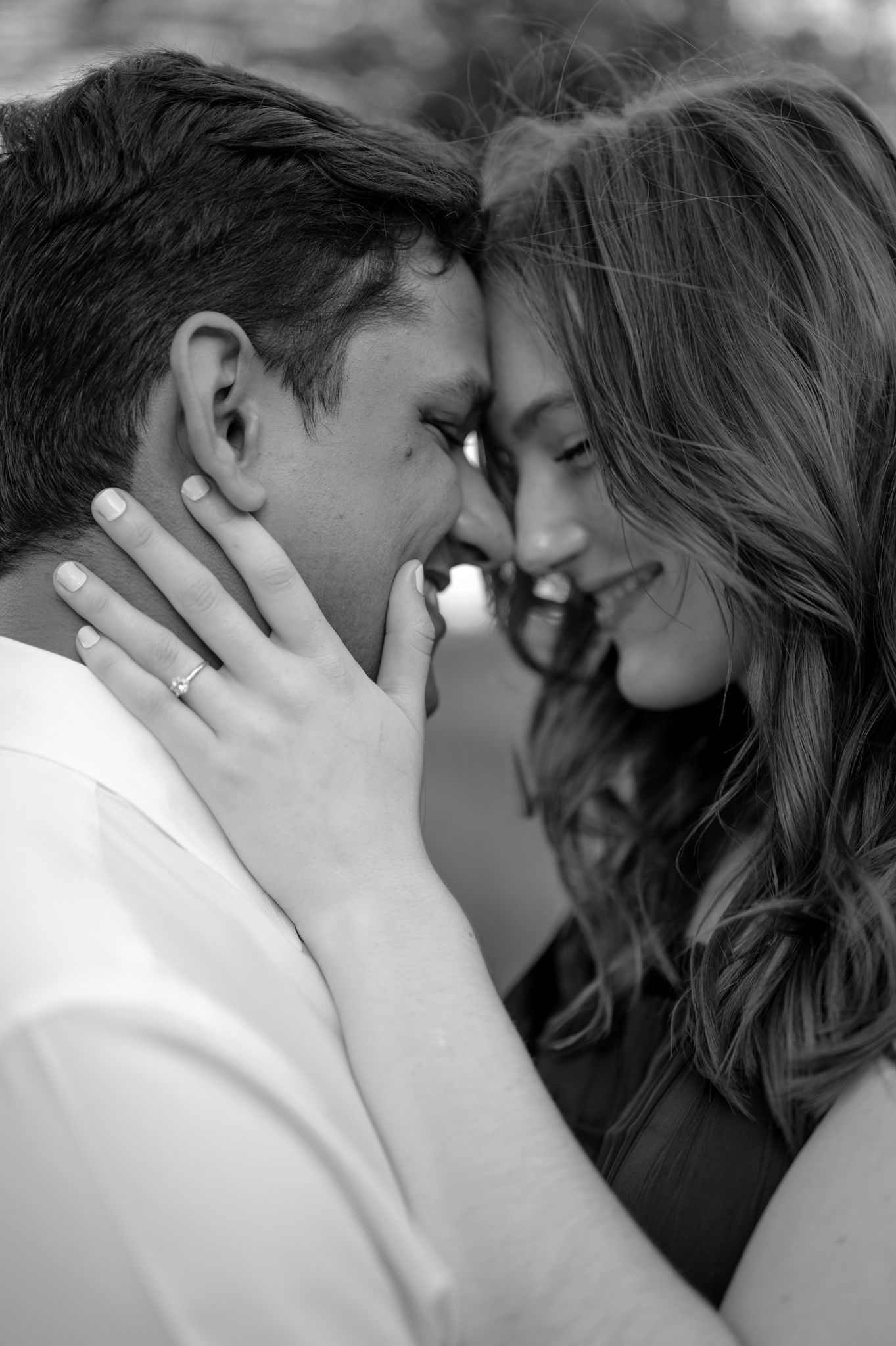 An intimate black and white portrait of a tender moment between two people.