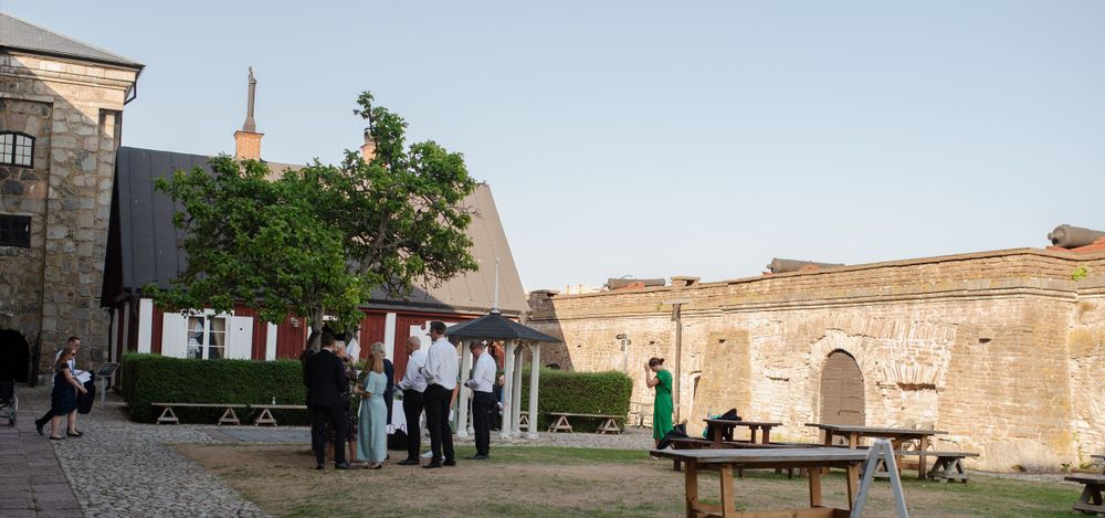 Historic stone fortress courtyard with people gathered outside.