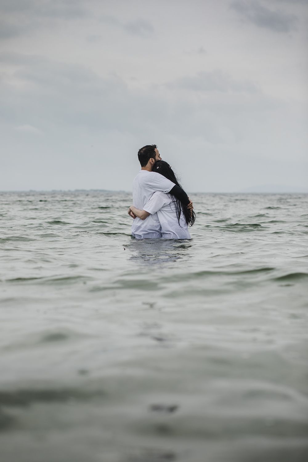 a couple standing in the water, hugging in Salthill, Galway, during their intimate couple photo session