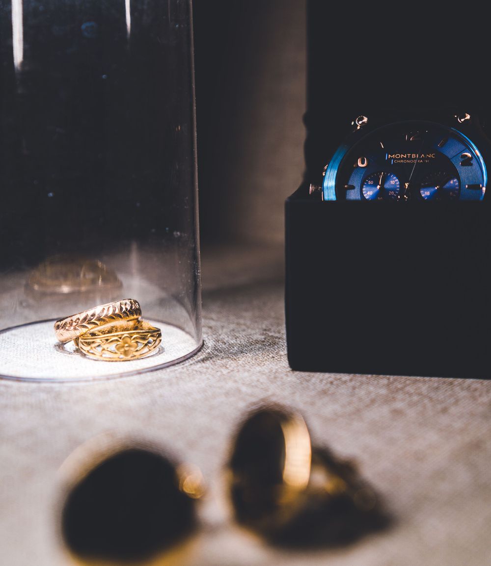 Gold jewelry and accessories arranged artistically with dramatic lighting and shadows.